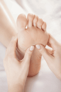 Un massage de pied au cours d'une séance de réflexologie plantaire